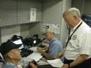 A veteran of 30 years coping with Gulf hurricanes, Dave Martin K5YFO/AAA6TX (standing), put his experience to work helping compile the
MARS 101
training cycle. Martin is Texas State Director of Army MARS and is shown here at the MARS position aboard a mobile command post. [MARS photo]