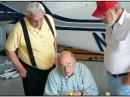 Bob, W8ZA, and Dallas, W3PP, look over the shoulder of Pete, W2GJ/C6APR, while calculating the weight and balance for the trip. [Robert Biss, W8ZA, Photo]