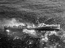 The USS Fiske broken in two and sinking in the Atlantic Ocean on 2 August 1944, after she was torpedoed. Note men abandoning ship by walking down the side of her capsizing bow section.